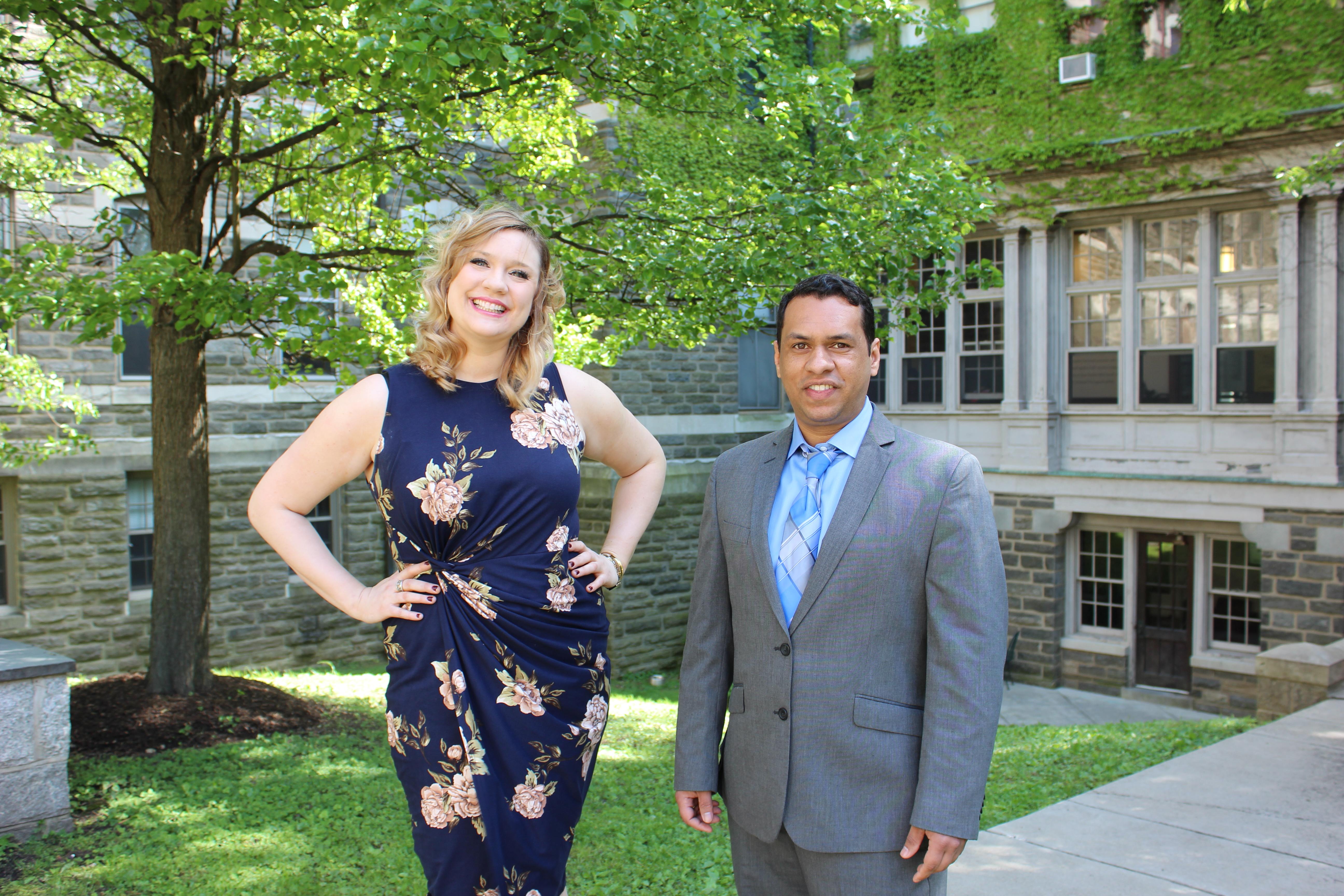 Man in suit and woman in pose in front of campus buildilng